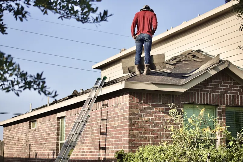 Professional roofer working on a residential roof in Henderson Corner